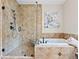 Luxurious bathroom featuring a tiled shower with glass door and soaking tub with beautiful tile surround at 9734 Tall Grass Cir, Lone Tree, CO 80124