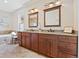 Elegant bathroom with a double sink vanity, granite countertops, and warm lighting, offering a luxurious feel at 9734 Tall Grass Cir, Lone Tree, CO 80124