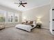 Cozy bedroom featuring neutral tones, plush carpet, a comfortable bed, and large windows for ample natural light at 9734 Tall Grass Cir, Lone Tree, CO 80124