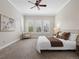 Spacious bedroom featuring neutral tones, plush carpet, a comfortable bed, and lots of natural light at 9734 Tall Grass Cir, Lone Tree, CO 80124