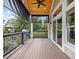 Covered deck with wood ceiling, motorized shades, and black railings overlooking the landscaped yard at 9734 Tall Grass Cir, Lone Tree, CO 80124