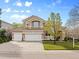Elegant two-story home with a three-car garage, manicured lawn, and a tile roof at 9734 Tall Grass Cir, Lone Tree, CO 80124