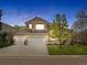 Elegant two-story home with a three-car garage, manicured lawn, and a tile roof at 9734 Tall Grass Cir, Lone Tree, CO 80124