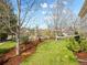 Landscaped front yard with mature trees, mulch beds, and lush green grass at 9734 Tall Grass Cir, Lone Tree, CO 80124