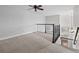 Spacious loft area with ceiling fan, carpeted floors, and wrought iron railing overlooking the staircase at 9734 Tall Grass Cir, Lone Tree, CO 80124