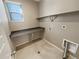 Practical laundry room with countertop, shelving, and tiled flooring at 1220 W 170Th Ave, Broomfield, CO 80023