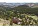Beautiful aerial view of a home nestled in a lush forest with mountain views at 33095 Bergen Mountain Rd, Evergreen, CO 80439