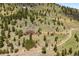 Aerial view of a large home located on a hill surrounded by lush trees and mountain scenery at 33095 Bergen Mountain Rd, Evergreen, CO 80439