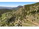 Scenic aerial view of a home in a mountainous region surrounded by trees at 33095 Bergen Mountain Rd, Evergreen, CO 80439