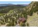 Scenic aerial view of a home nestled in a mountain valley surrounded by trees at 33095 Bergen Mountain Rd, Evergreen, CO 80439