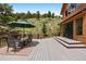 Spacious outdoor deck with dining area, mountain views, and access to backyard at 33095 Bergen Mountain Rd, Evergreen, CO 80439