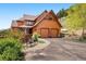 Attractive home showcasing a two-car garage, well-maintained driveway, and charming front patio with bench seating at 33095 Bergen Mountain Rd, Evergreen, CO 80439