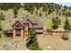 Beautiful home featuring a spacious deck and stunning views, blending seamlessly with the natural hillside surroundings at 33095 Bergen Mountain Rd, Evergreen, CO 80439