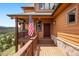 Inviting front porch featuring an American flag, lovely greenery, and elegant stone accents for a welcoming entrance at 33095 Bergen Mountain Rd, Evergreen, CO 80439