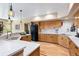 Bright kitchen with a peninsula, stainless appliances, wood cabinets, and views to the backyard at 33095 Bergen Mountain Rd, Evergreen, CO 80439