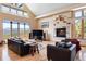 Elegant living room with a stone fireplace, mountain views, and comfortable leather seating for a cozy atmosphere at 33095 Bergen Mountain Rd, Evergreen, CO 80439