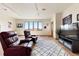 Relaxing living room with comfortable seating, natural light, and a modern rug at 33095 Bergen Mountain Rd, Evergreen, CO 80439