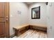 Mudroom with bench seating, custom mirror, hooks, and convenient access to the exterior at 33095 Bergen Mountain Rd, Evergreen, CO 80439