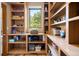 Walk-in pantry with custom shelving, hardwood floors, storage space, and bright light from a window at 33095 Bergen Mountain Rd, Evergreen, CO 80439