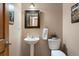 Cozy powder room with pedestal sink, toilet, towel rack, custom mirror and decor at 33095 Bergen Mountain Rd, Evergreen, CO 80439