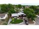 Aerial view of home with mature trees, manicured lawn, garage, and paved driveway in a quiet neighborhood at 147 Wallace St, Northglenn, CO 80234