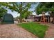 Landscaped backyard with a small patch of grass, a large protective cover and mature tree providing ample shade at 147 Wallace St, Northglenn, CO 80234
