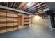 Unfinished basement area features wooden shelves and exposed ceiling rafters at 147 Wallace St, Northglenn, CO 80234