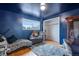Cozy blue bedroom featuring a window, closet, unique decor and a comfortable zebra-striped seating area at 147 Wallace St, Northglenn, CO 80234