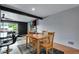 Inviting dining area with a modern table set, connecting to a living space and a stylish kitchen with barstools at 147 Wallace St, Northglenn, CO 80234