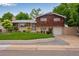 Charming home boasts mature trees, landscaped lawn, brick accents, and an attached one-car garage at 147 Wallace St, Northglenn, CO 80234