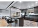 Modern kitchen showcasing gray cabinetry, a black countertop island with bar seating, and stainless steel appliances at 147 Wallace St, Northglenn, CO 80234