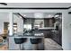 Elegant kitchen featuring dark gray cabinetry, stainless steel appliances, and a breakfast bar with seating at 147 Wallace St, Northglenn, CO 80234