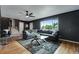 Open-concept living room with a large sectional sofa, modern decor, and staircase at 147 Wallace St, Northglenn, CO 80234