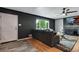 Modern living room with hardwood floors, large sectional sofa, and a black accent wall at 147 Wallace St, Northglenn, CO 80234