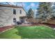 Beautifully landscaped backyard with a green lawn, brick patio, and covered pergola at 20000 Mitchell Pl # 9, Denver, CO 80249