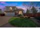 Charming two-story home boasts a lush green lawn, brick accents, and an attached two-car garage at 20000 Mitchell Pl # 9, Denver, CO 80249