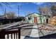 Wide backyard shot featuring a green garage, stone walkway, landscaping, and a cozy pergola area at 4403 Alcott St, Denver, CO 80211