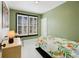 Bedroom with green walls, white floors, a large window with shutters, and floral bedding at 4403 Alcott St, Denver, CO 80211