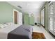 Bedroom with vintage green accents, white floors and walls, and shuttered window at 4403 Alcott St, Denver, CO 80211