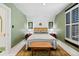 Bedroom with green walls, white trim, wood floors, and shuttered window at 4403 Alcott St, Denver, CO 80211