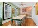 Bright dining room with painted brick wall, hardwood floors, and white window shutters at 4403 Alcott St, Denver, CO 80211