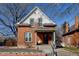 Inviting two-story red brick house with a cozy front porch and manicured landscaping at 4403 Alcott St, Denver, CO 80211