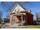 Classic brick home boasts a quaint front porch with seating and mature trees at 4403 Alcott St, Denver, CO 80211