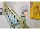 View of the staircase with light green walls and unique decor at 4403 Alcott St, Denver, CO 80211
