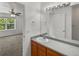 Bright bathroom with updated fixtures, wood cabinets, and views into the adjacent bedroom at 9024 Gale Blvd # 3, Thornton, CO 80260