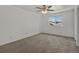 Spacious bedroom featuring plush carpeting, a ceiling fan, and a large window at 9024 Gale Blvd # 3, Thornton, CO 80260