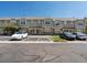 Townhome exterior with gray siding, stone accents, visitor parking, and well-maintained landscaping at 9024 Gale Blvd # 3, Thornton, CO 80260