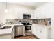 Modern kitchen with stainless steel appliances, white cabinets, and gray subway tile backsplash at 2110 Decatur St, Denver, CO 80211