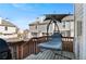 Relaxing back deck with a swing chair, wooden railing, and a view of the townhouse complex at 10715 Foxwood Ct, Parker, CO 80138