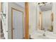 Bathroom with a white vanity and framed mirror, next to a hallway with neutral paint at 10715 Foxwood Ct, Parker, CO 80138